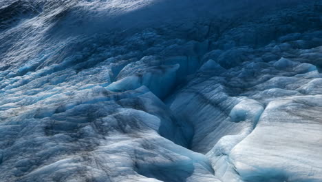 close-up of a glacier's blue and white ice formations and deep crevasses