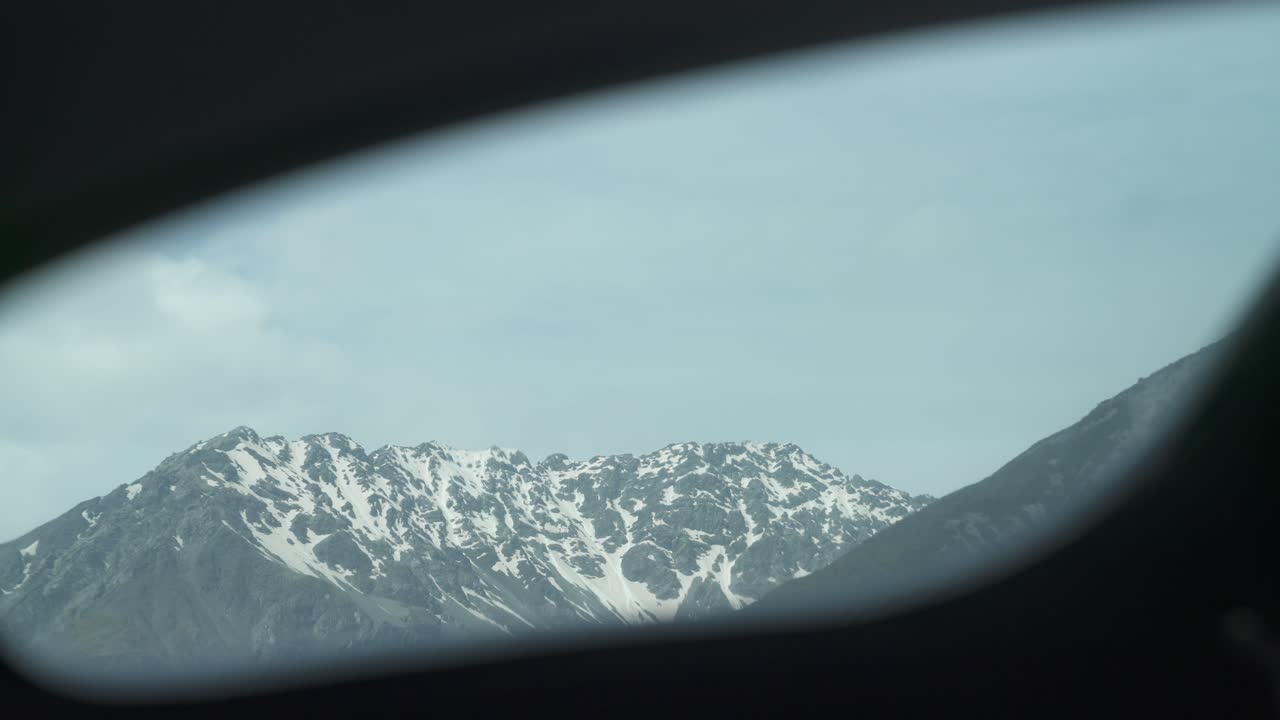 Ripresa di montagna innevata dal finestrino dell'elicottero.