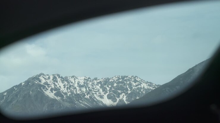 Ripresa di montagna innevata dal finestrino dell'elicottero.