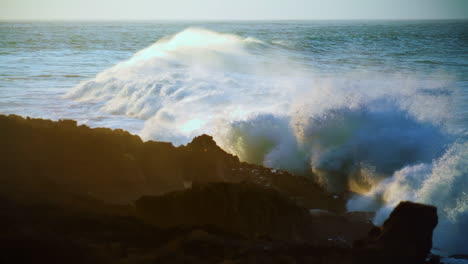 la dramática costa del océano al amanecer en cámara lenta, poderosas olas espumosas.