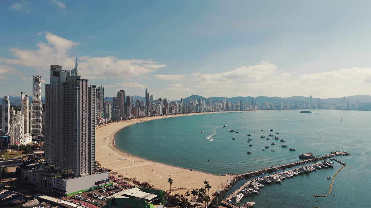 Aerial drone establishing fly at Balneário Camboriú, Beach city in Brazil under summer sunlight