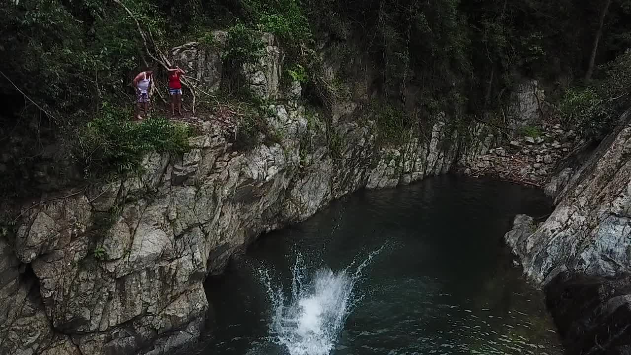 Slow Motion Aerial View of Man Flipping in the Air and Jumping into Pond in Rainforest of Puerto Rico