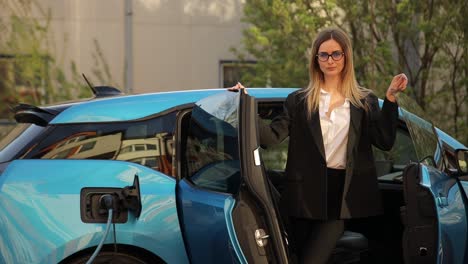 a professional woman in a business suit getting out of an electric car being charged, showcasing sustainable transportation and ecofriendly practices