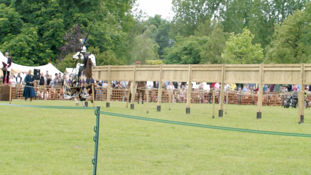 4K slow motion shot of the clashing of lances of mounted knights in full suit of armour, at the Queen's Joust tournament at Leeds Castle, Kent, England