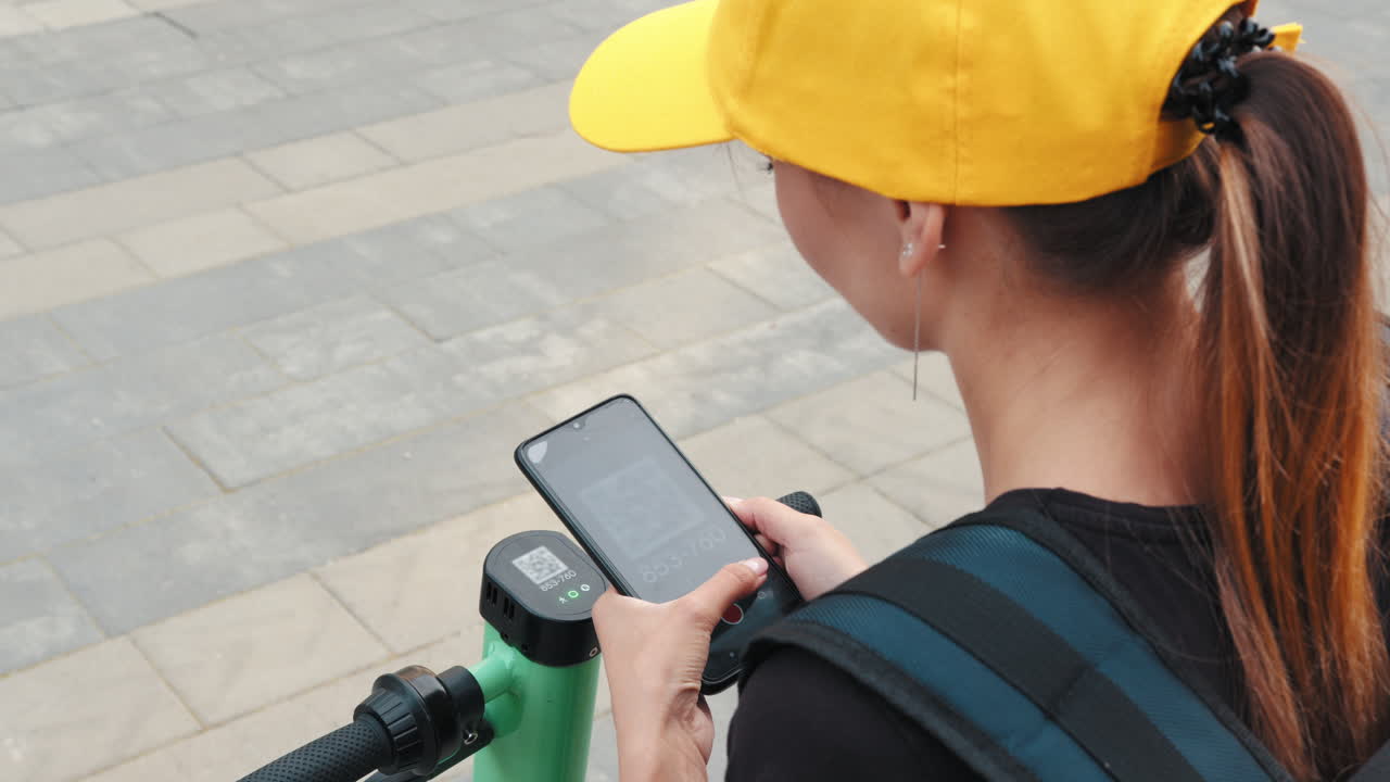mujer usando teléfono inteligente con scooter eléctrico