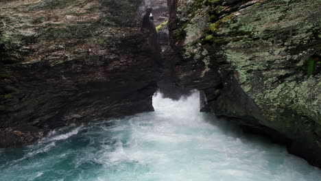 camera pulls out slowly from a narrow crevice in a craggy rock face