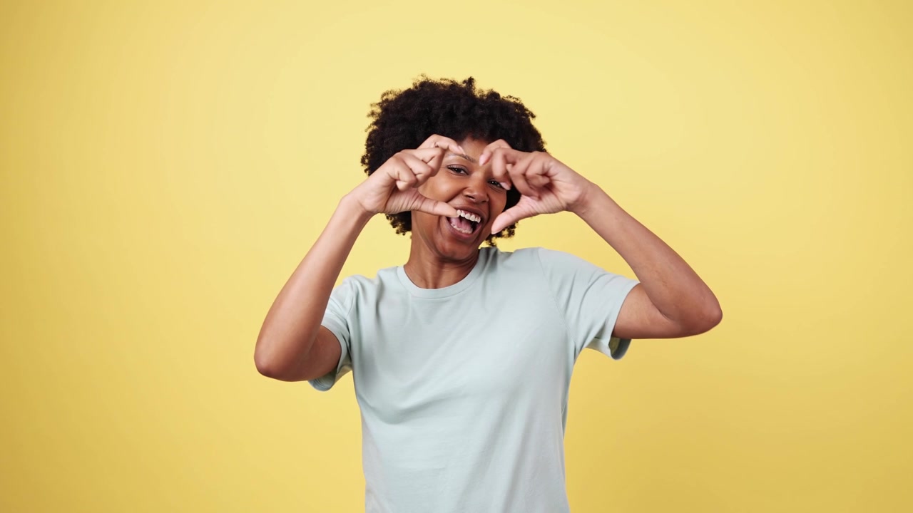 Smiling Young Black Woman Making Heart Shape with Hands