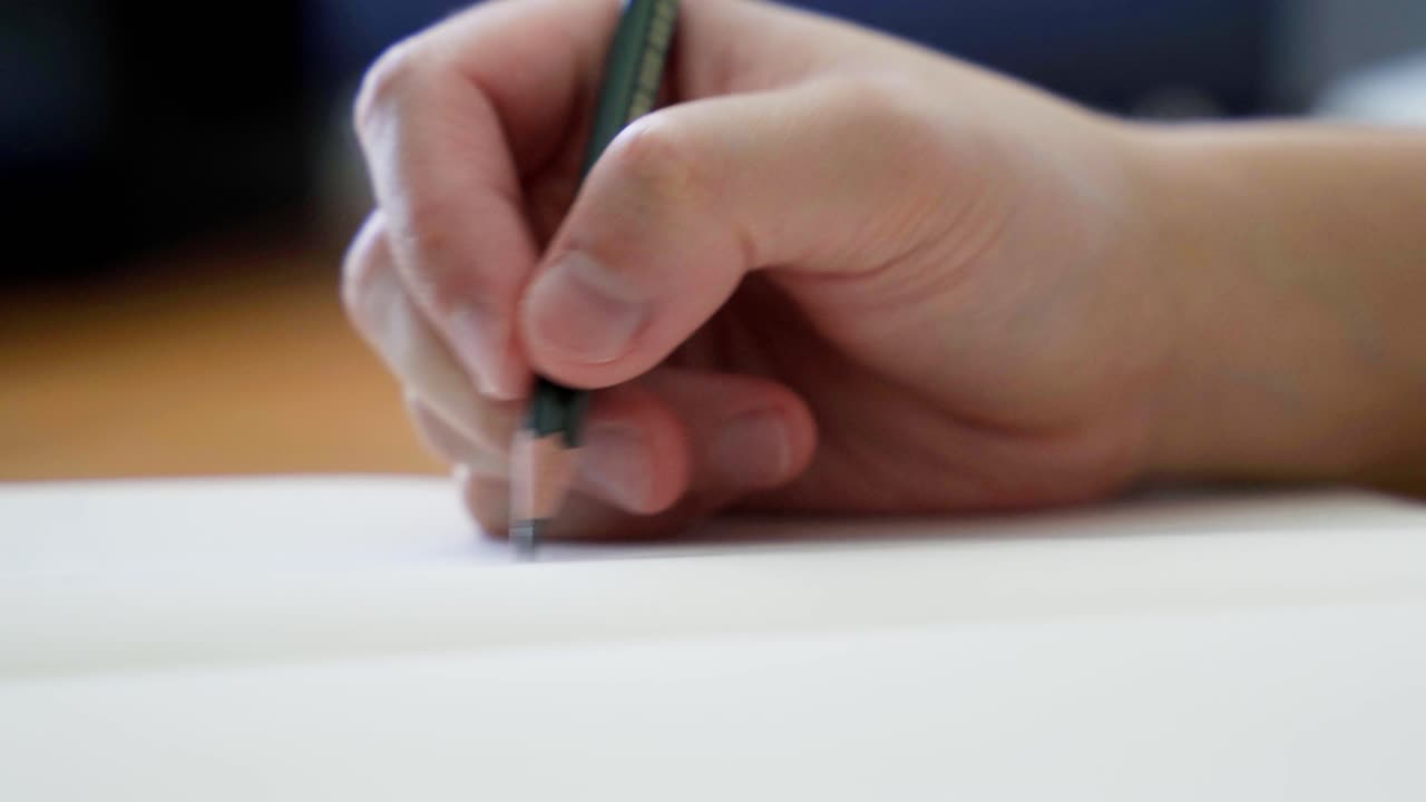 나무 데스크 ⁇  에 있는 검은색 스케치북 에서 연필 으로 스케치 하는 것