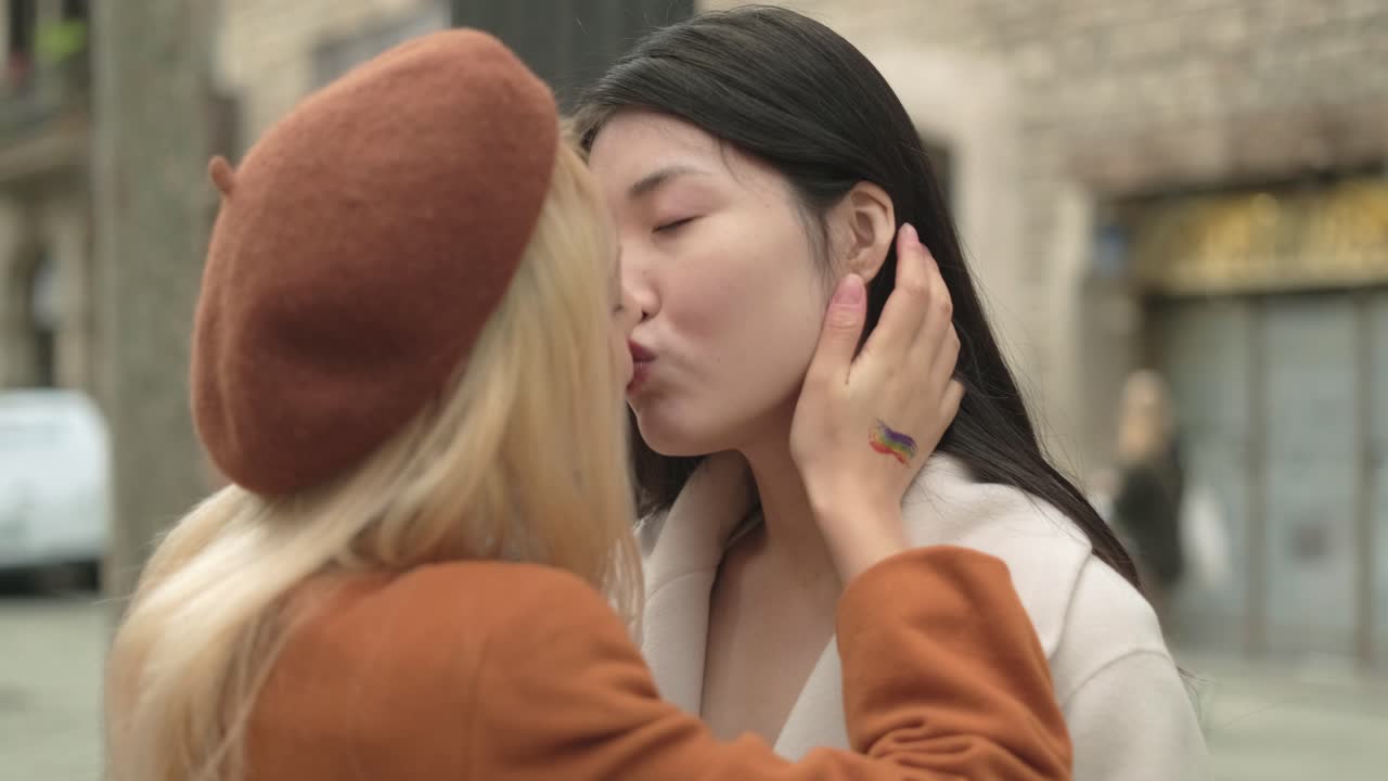 Two women kissing with rainbow tattoo