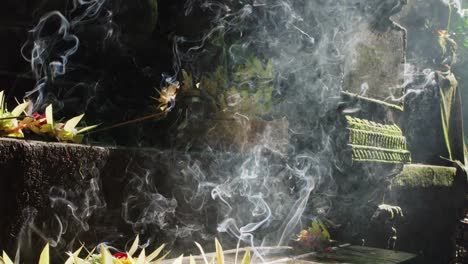 offerings with incense smoke in sebatu holy temple in bali