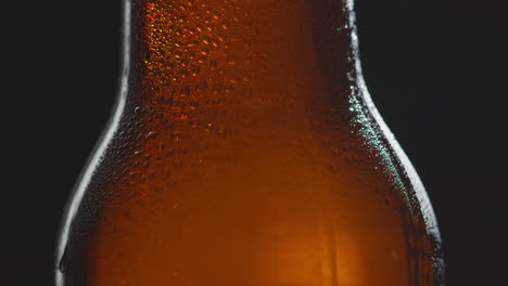 cierre de gotas de condensación en una botella giratoria de cerveza fría o bebida gaseosa