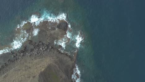 Drone-top-down-shot-of-waves-bounce-on-rocks-at-the-rocky-coast