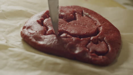 a sharp knife outline a design of a raw cookie dough, static close up