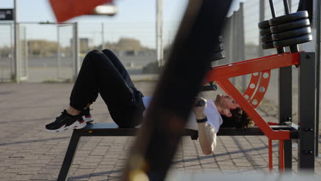 man performing chest press exercise at an outdoor gym