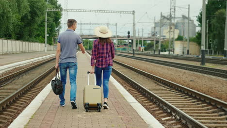 a young couple with bags goes on the platform at the station 3