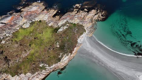 aerial top down of clear ocean water and sandy path connecting diamond island in tasmania