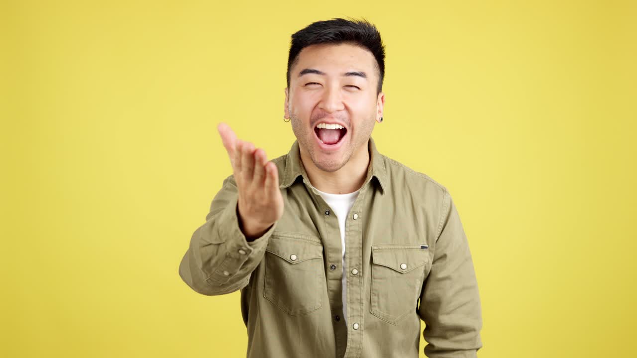 Young Asian man expressing love and affection with hand gestures