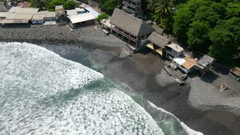 Plano-Completo-A-Vista-De-Pájaro,-Una-Persona-Parada-En-La-Orilla-De-La-Playa-Bitcoin-En-Un-Día-Soleado-En-El-Salvador-México,-Olas-Corriendo-Hacia-La-Costa