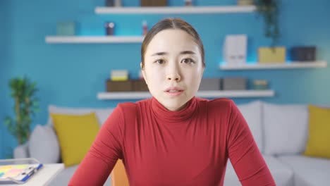 Asian-woman-looking-at-the-camera-with-sad-eyes-in-response-to-the-news-she-saw-on-the-laptop-screen.