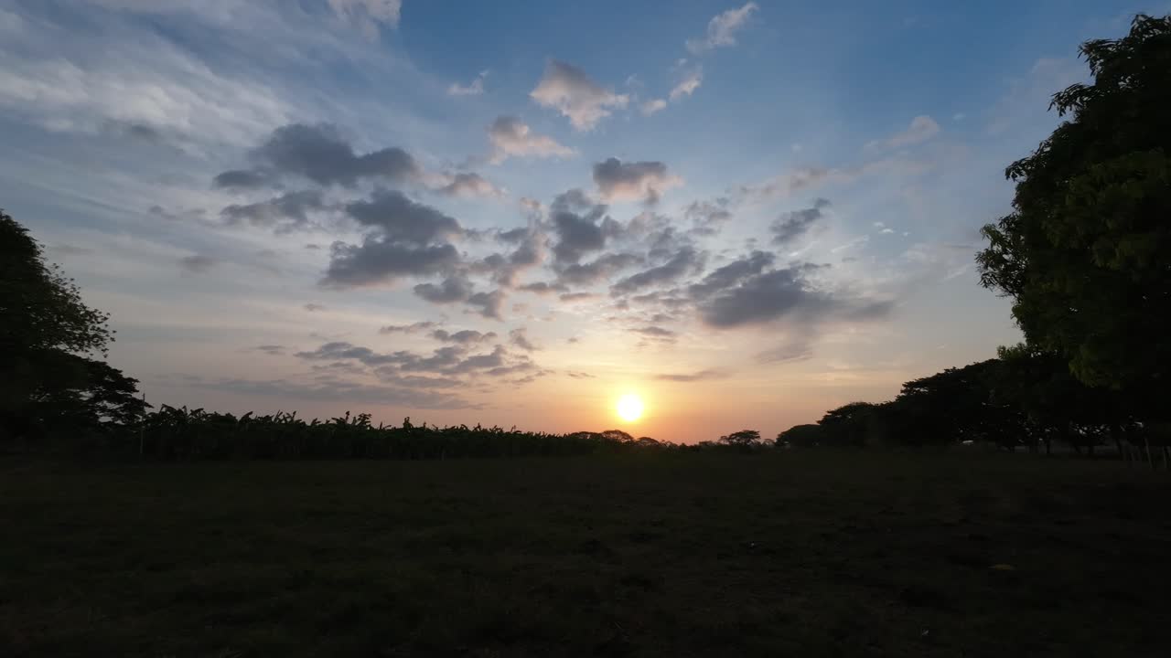 Morning sun rises over the plains with scattered clouds in a peaceful time lapse