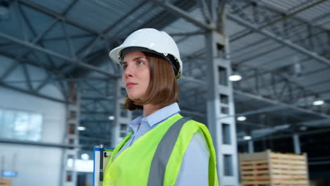 Portrait-storehouse-worker-smiling-green-reflective-uniform-helmet-focusing