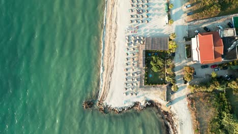 Albanien,-Smaragdgrünes-Wasser-Des-Ionischen-Meeres-Am-Strand-Mit-Sonnenschirmen-Und-Sonnenliegen