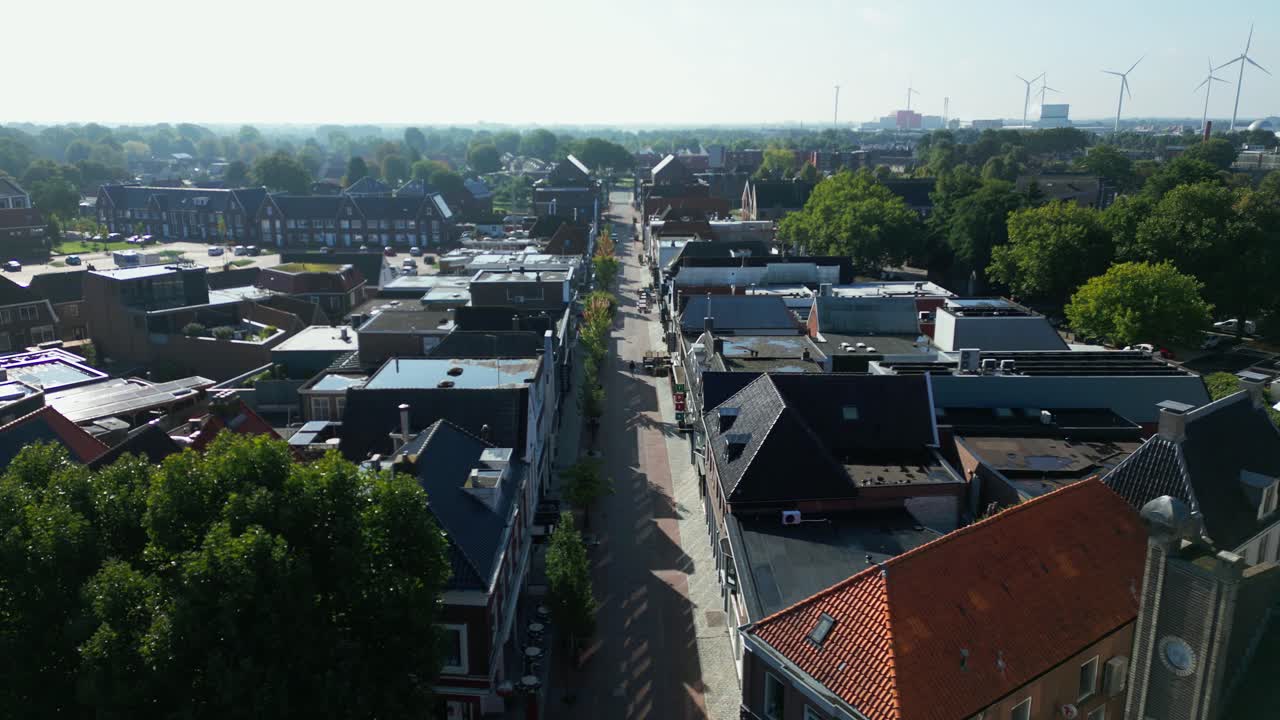 Drone footage of Coevorden’s main street lined with buildings, trees casting long shadows on rooftops. Captured in Coevorden, Drenthe, Netherlands (Coevorden, Drenthe, Nederland)
