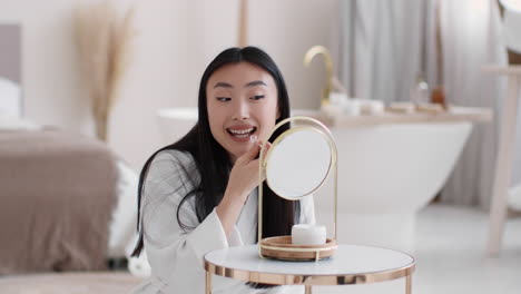Woman applying face cream in front of a mirror
