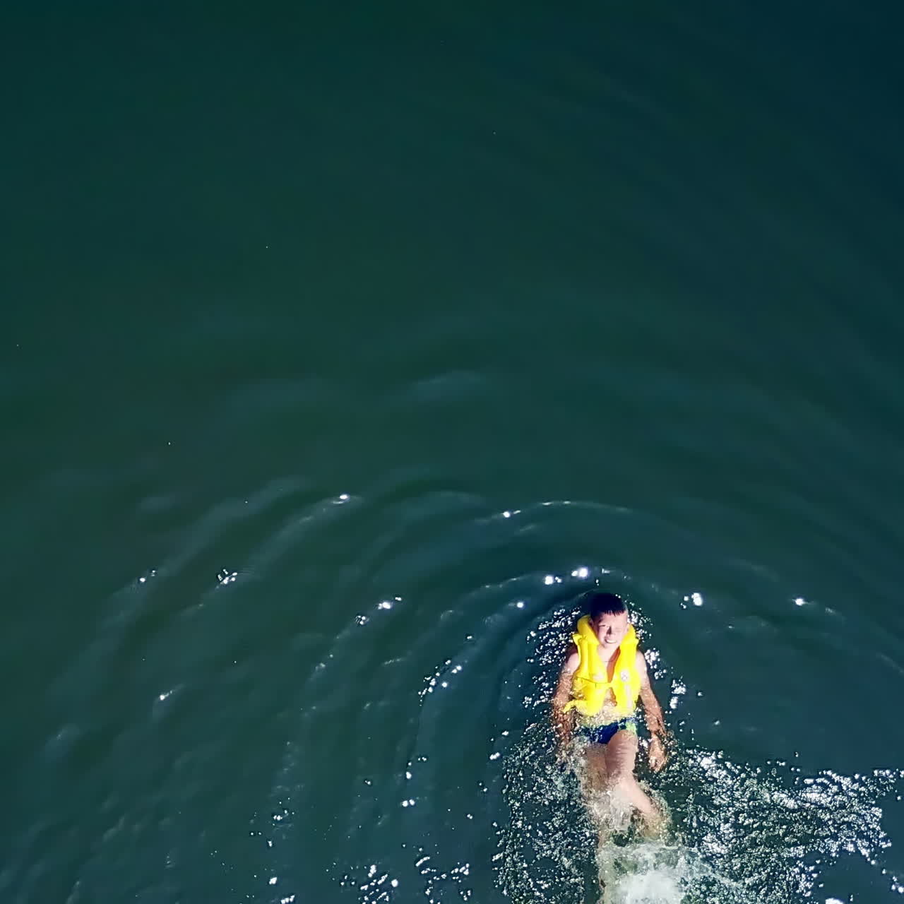 The guy is swimming in the river. Happy children on summer vacation. Aerial view