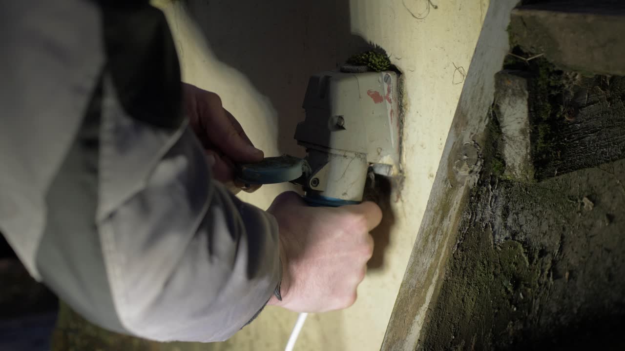 Electrician plugging in three-phase outdoor plug