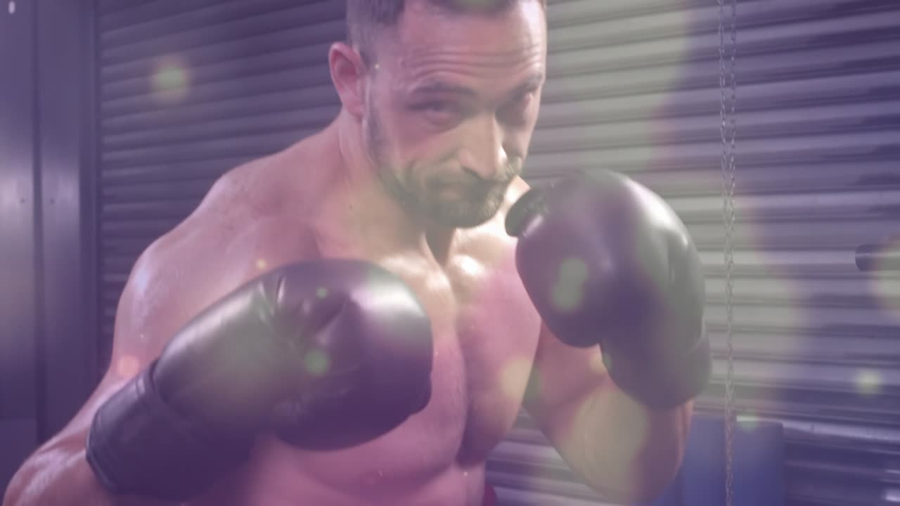Animation of light spots over caucasian man boxing at gym