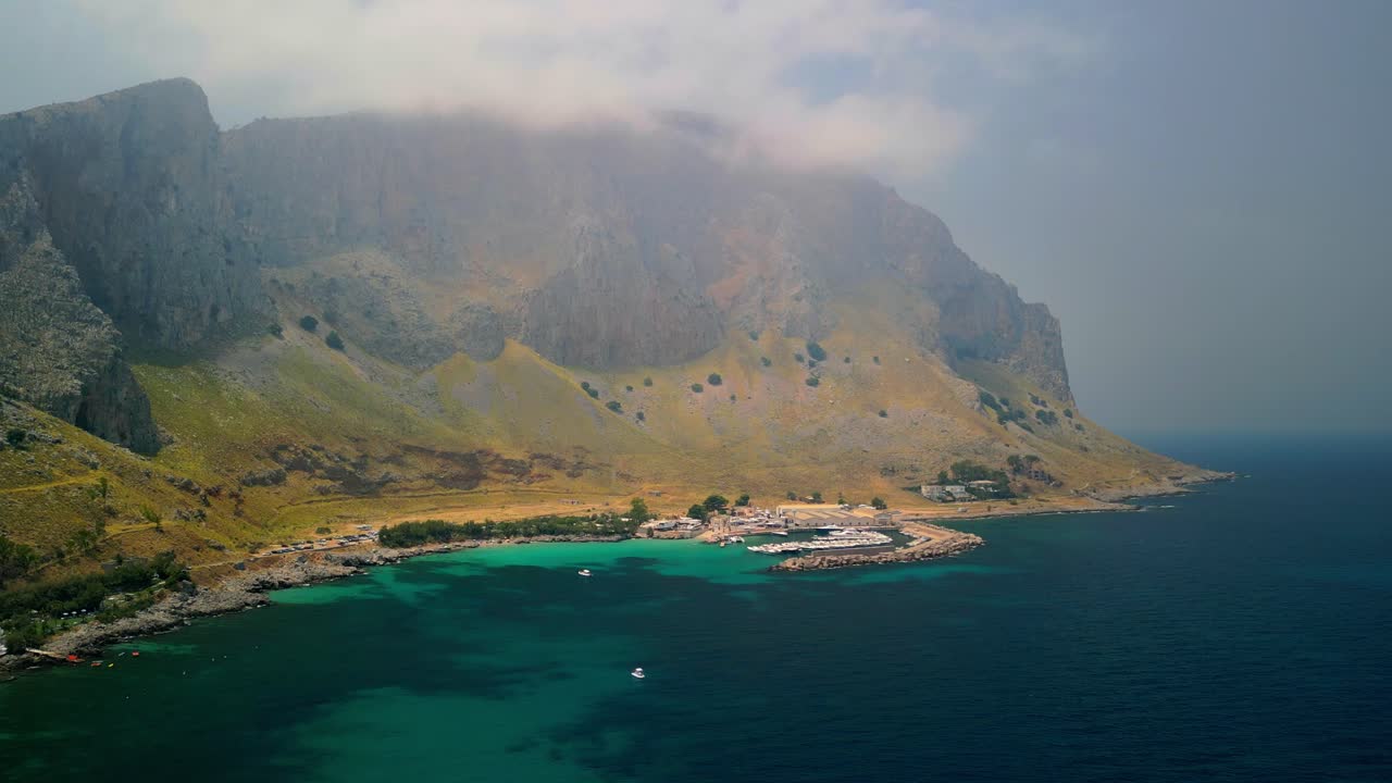 Terrasini liman bölgesinin sıra sıra tekneler ve koruyucu iskelelerle dron görüntüsü. Terrasini'yi klasik bir Sicilya sahil kasabası olarak sergileyen sinematik havadan görüntü. Terra'yı ortaya çıkaran havadan dron çekimi