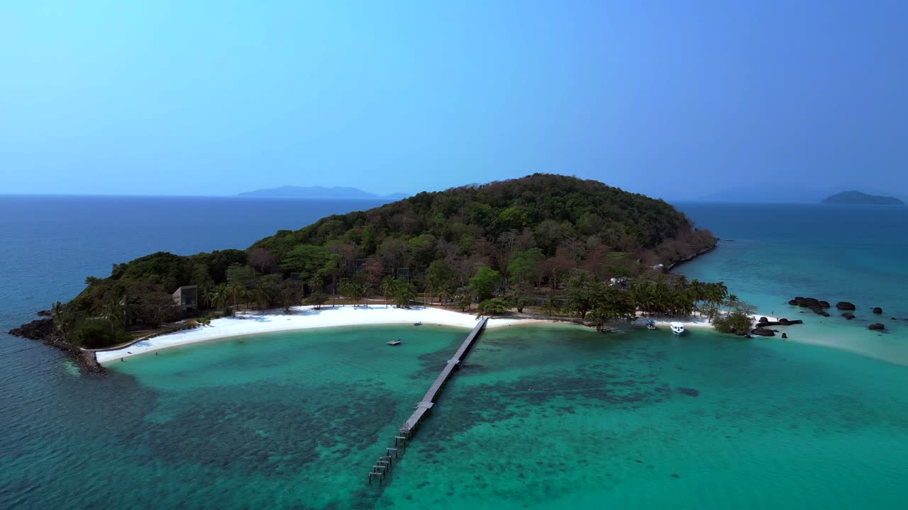 Koh Kham Island with crystal clear turquoise water, white sand beaches and lush tropical vegetation, a popular tourist destination in Thailand. Best aerial view flight static tripod hovering drone