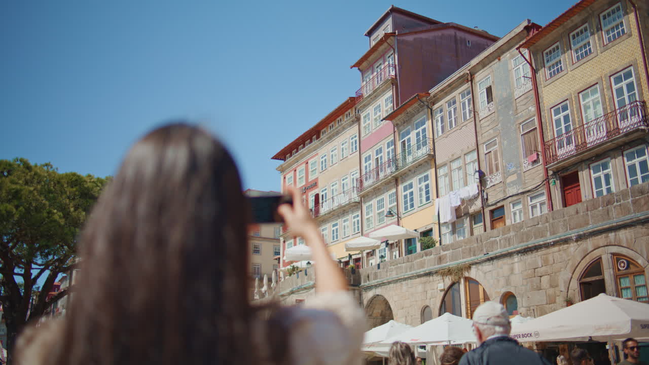 Travelling model make photos of town buildings closeup. Woman enjoying trip