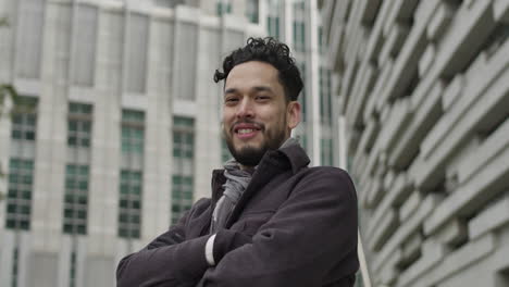 Portrait-of-happy,-confident-middle-aged-Hispanic-ethnicity-man-in-casual-autumn-outfit,-smiling-confidentially-in-outdoors-in-central-business-district