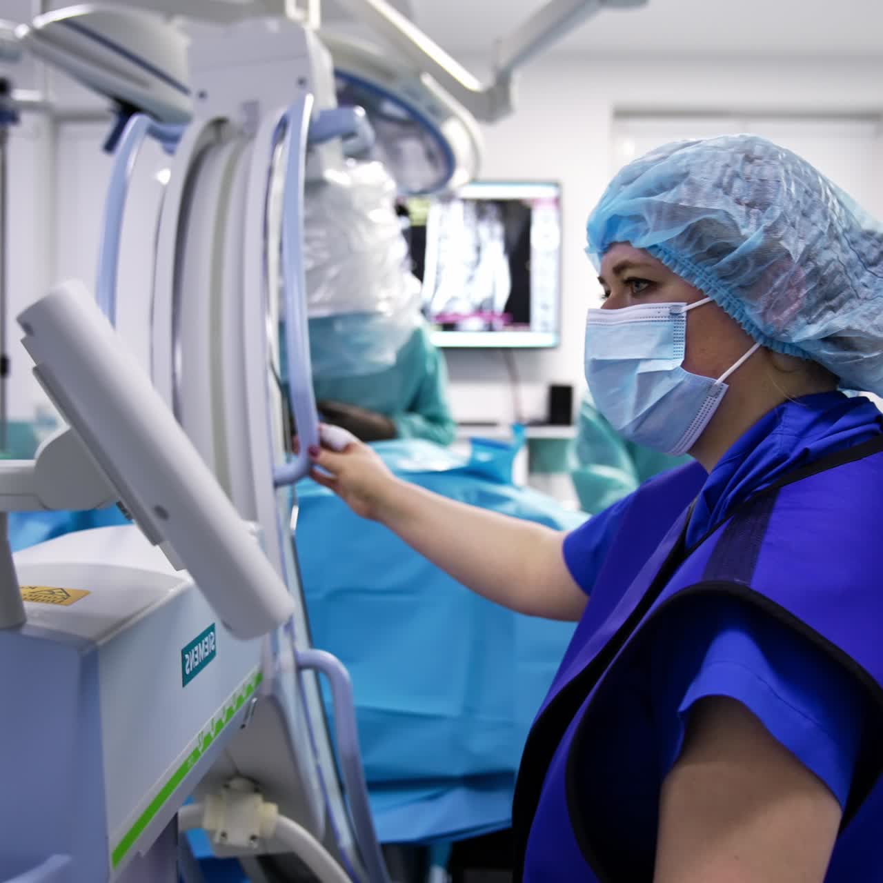 Modern surgery theatre full of technological equipment. Medical staff standing at their places to control various surgery equipment