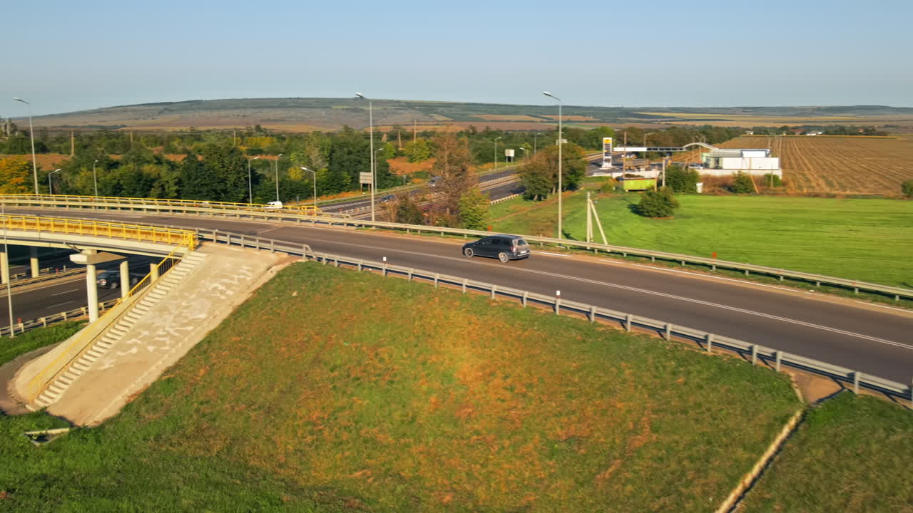CHISINAU, MOLDOVA - AUGUST 25, 2021: Aerial drone view of a road junction with moving cars and nature, greenery, fields, Moldova
