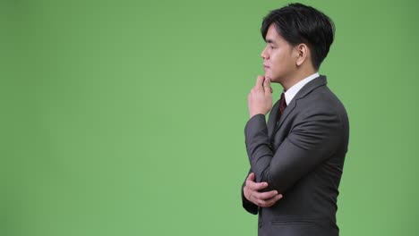 녹색 배경에 젊은 잘생긴 아시아 사업가