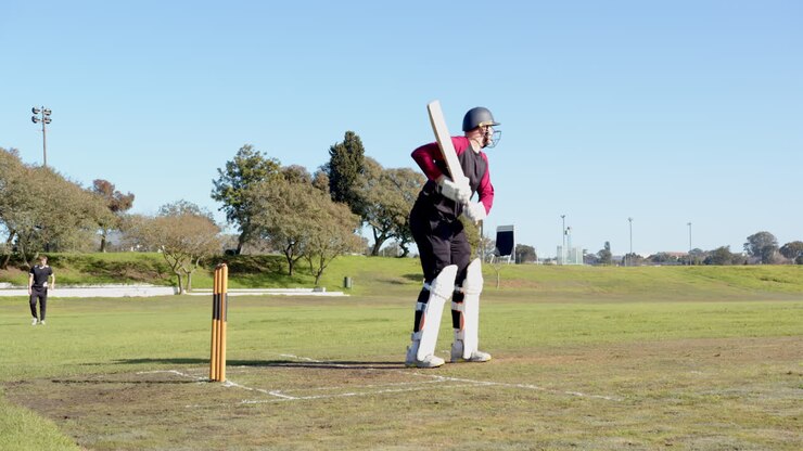 Correndo em campo, jogador de críquete focado em alcançar o wicket rapidamente.