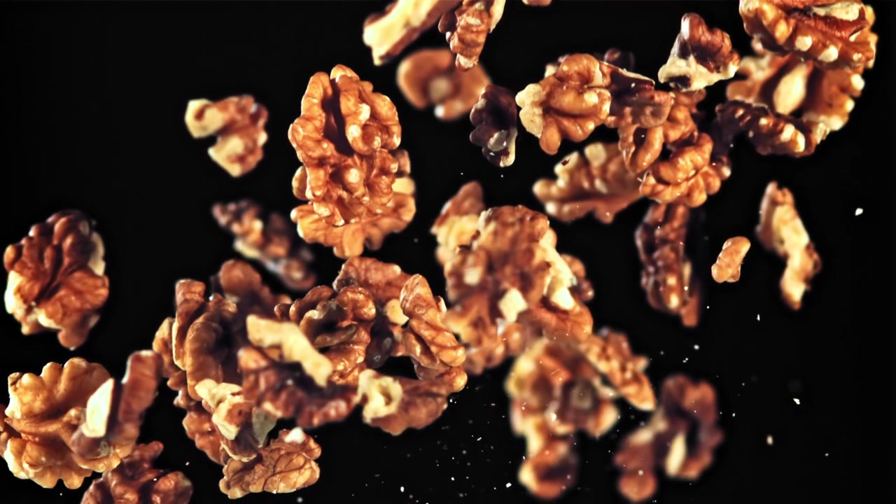 Shelled Walnuts Falling in Slow Motion on Black Background