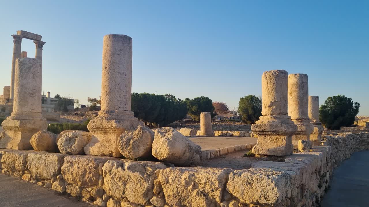 Evening sunlight illuminates the Temple of Hercules ruins at Amman Citadel, Jordan, highlighting ancient Roman architecture on Jabal al-Qal'a with panoramic city views and a warm, historic atmosphere