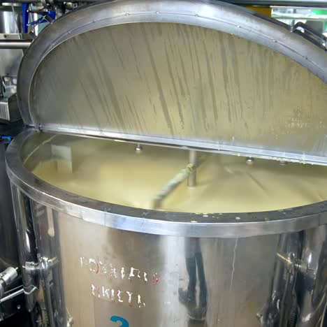looking inside the large cistern full of sour cream which is being automatically mixed. close look at the dairy tank with gradual distancing from it