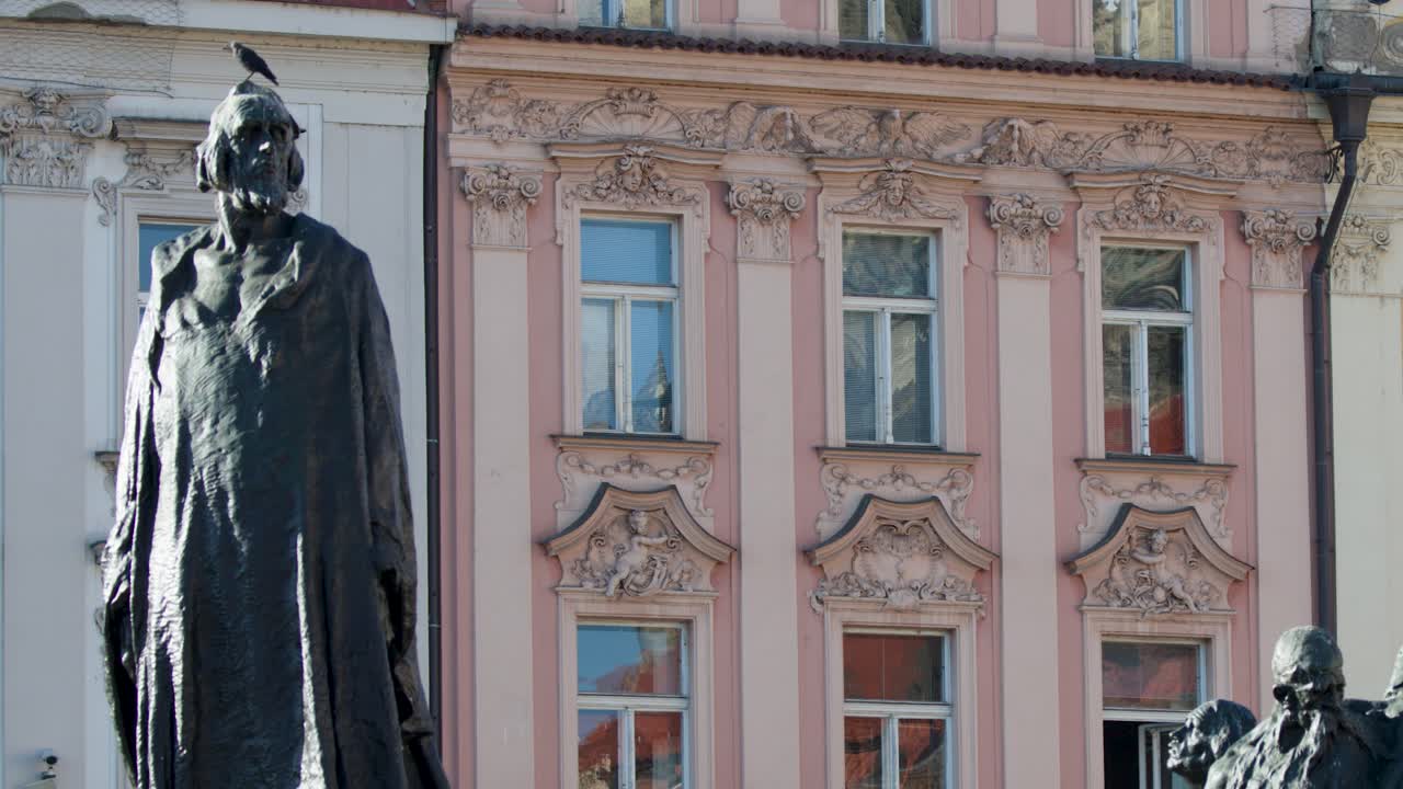 Daylight camera pan reveals Jan Hus Memorial and ornate baroque buildings in Prague city center