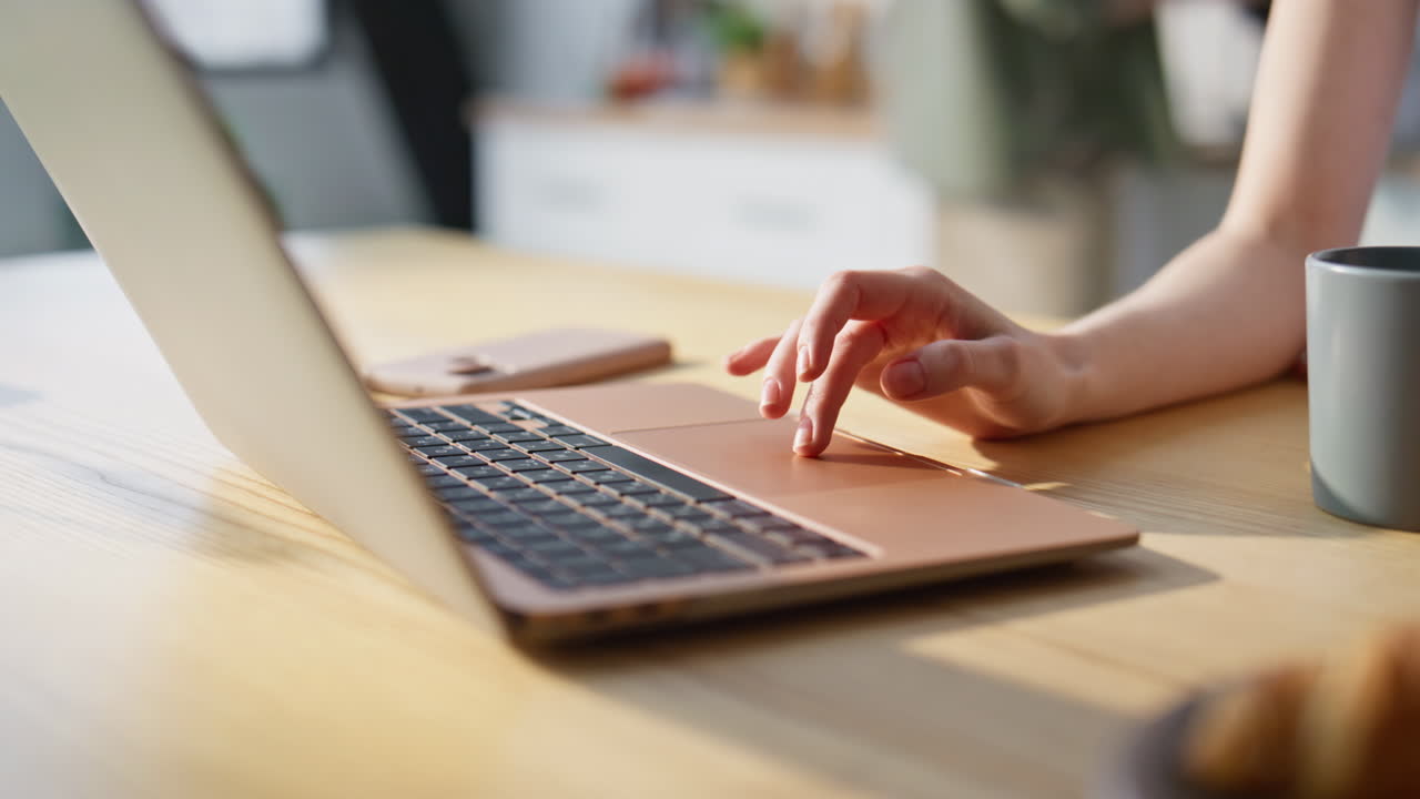 Freelancer woman hand typing laptop in kitchen taking coffee from fiance closeup