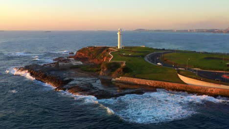 Vista-Aérea-De-La-Cabeza-Y-El-Faro-De-Wollongong-Con-Olas-Espumosas-Rompiendo-En-Nsw,-Australia