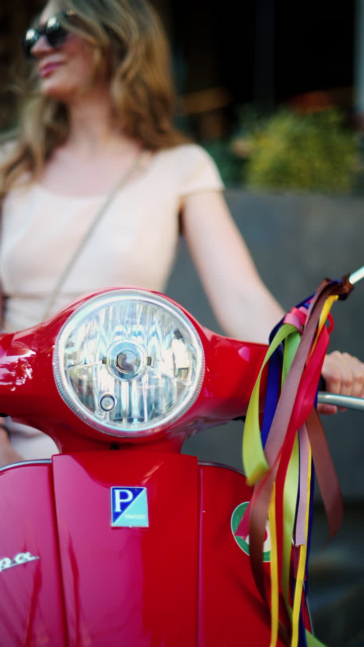 Chisinau, Moldova - June 27, 2024: Woman standing on a red Vespa scooter with colourful decoration hanging from the mirrors. Vertical
