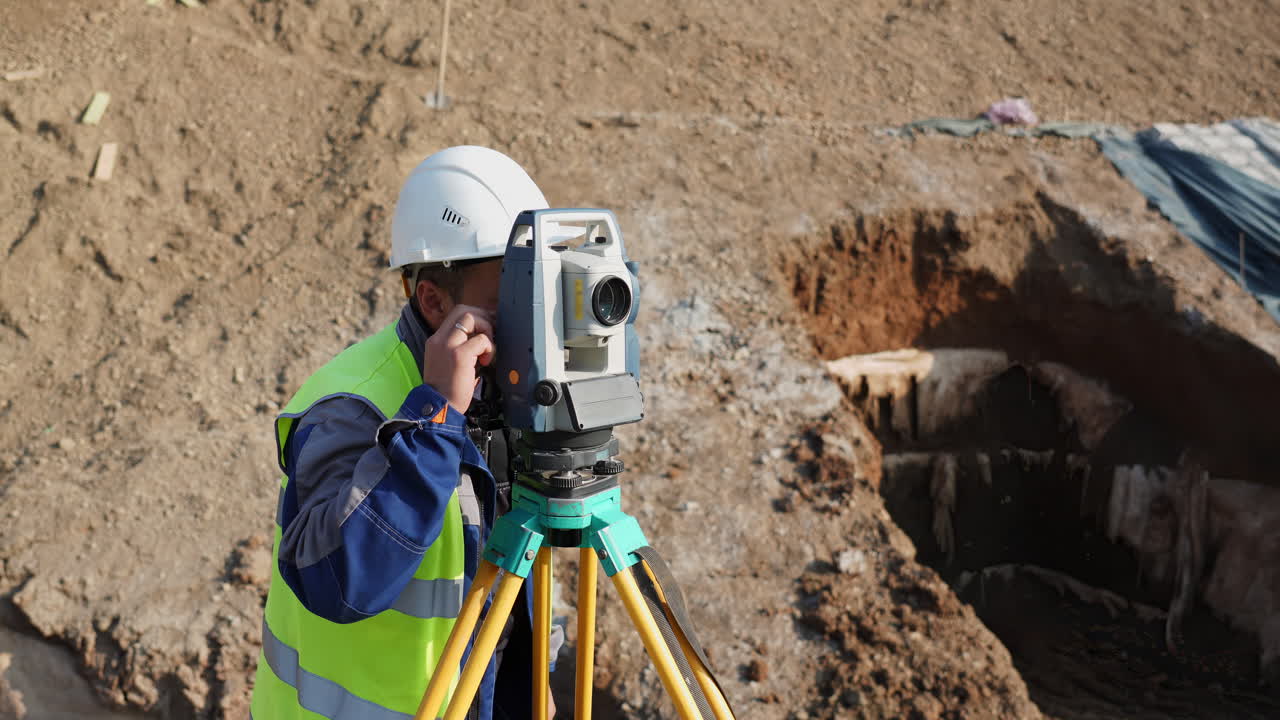 Surveyor working with total station on a construction site