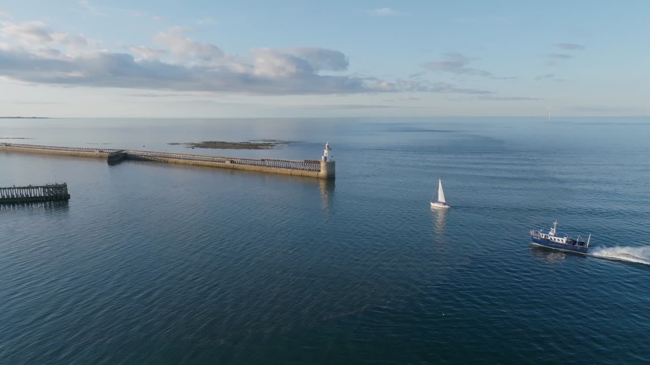 Drone clip showing sail boat and larger motorised boat entering harbour