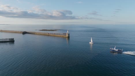 drone clip showing sail boat and larger motorised boat entering harbour