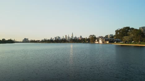 Vista-De-Bajo-Nivel-De-Un-Lago-Con-El-Horizonte-De-La-Ciudad-Al-Fondo.